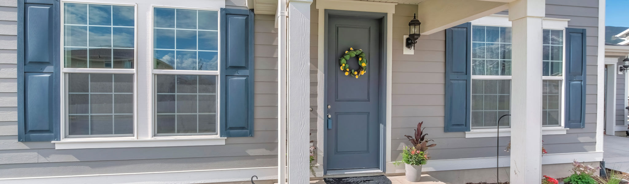 Home Exterior With Gray Wood Vinyl Siding And White Frames